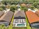 Aerial view of backyard with pool and neighborhood featuring well-maintained lawns and lush greenery at 2505 Dharma Cir, Kissimmee, FL 34746