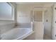 Bright bathroom featuring a soaking tub, separate shower, and neutral tile finishes at 2505 Dharma Cir, Kissimmee, FL 34746
