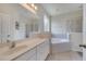 Bright bathroom features a soaking tub, shower, and vanity with a white countertop at 2505 Dharma Cir, Kissimmee, FL 34746
