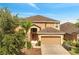 Two-story home with a two-car garage, arched front door, desert landscaping and a palm tree in the front yard at 2505 Dharma Cir, Kissimmee, FL 34746