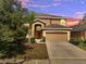 Two-story home with a two-car garage, arched front door, desert landscaping and a palm tree in the front yard at 2505 Dharma Cir, Kissimmee, FL 34746