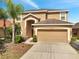 Charming two-story home showcasing manicured lawn, mature palm and a two car garage at 2505 Dharma Cir, Kissimmee, FL 34746