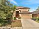 Two-story home with a two-car garage, arched front door, desert landscaping and a palm tree in the front yard at 2505 Dharma Cir, Kissimmee, FL 34746