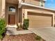 Inviting front entrance featuring a two car garage and a well-manicured lawn at 2505 Dharma Cir, Kissimmee, FL 34746