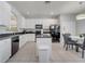 Spacious kitchen with white cabinets, black appliances, a kitchen island, and tiled floors at 2505 Dharma Cir, Kissimmee, FL 34746
