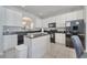 White kitchen with black appliances, granite countertops, and a central island for food preparation at 2505 Dharma Cir, Kissimmee, FL 34746