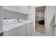 Bright laundry room with white washer, dryer, and cabinetry, adjacent to the garage at 2505 Dharma Cir, Kissimmee, FL 34746