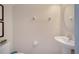 Neutral powder room featuring a pedestal sink, oval mirror, and framed art at 2505 Dharma Cir, Kissimmee, FL 34746