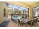 Screened patio with dining set, chaise lounge and fenced pool for outdoor relaxation at 2769 Bookmark Dr, Kissimmee, FL 34746
