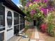 Charming screened in lanai with access to a lush, fenced-in backyard full of colorful plants and flowers at 112 10Th St, St Cloud, FL 34769