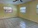 This bedroom features ceramic tile flooring, a ceiling fan, and natural lighting from the three windows at 112 10Th St, St Cloud, FL 34769
