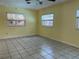 This bedroom features ceramic tile flooring, a ceiling fan, and natural lighting from the three windows at 112 10Th St, St Cloud, FL 34769