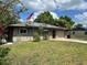Charming home with an American flag out front, attached garage, and solar panels on the roof at 112 10Th St, St Cloud, FL 34769