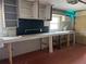 Attached garage featuring pegboard, storage, work bench, and open shelving at 112 10Th St, St Cloud, FL 34769