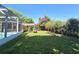 This backyard features a beautiful screened-in pool with adjacent shade trees, a pergola and garden at 112 10Th St, St Cloud, FL 34769