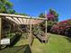 This backyard has a beautiful garden setup including a pergola, elevated garden beds, and a welcoming sign at 112 10Th St, St Cloud, FL 34769