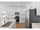 Modern kitchen featuring stainless steel appliances, white cabinets, and wood floors at 2007 Stetson Ave, Eagle Lake, FL 33839