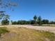 Spacious vacant lot with potential for building, surrounded by lush trees and a clear blue sky at 3664 Cord Ave, St Cloud, FL 34772