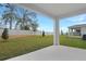 A beautiful backyard with a covered patio, lush green lawn, and privacy fence at 1651 Sugarbelle Cir, Mascotte, FL 34753