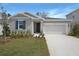 Charming single-Gathering home featuring a two-car garage and a well-manicured front yard at 1651 Sugarbelle Cir, Mascotte, FL 34753
