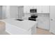 Bright kitchen featuring white cabinets, stainless steel appliances, and a large island at 1651 Sugarbelle Cir, Mascotte, FL 34753