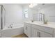 Bathroom features a double sink vanity, soaking tub with tile surround, and modern fixtures at 1655 Sugarbelle Cir, Mascotte, FL 34753