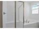 Bright bathroom boasts a tub, shower with glass door, and white tiled surround at 1655 Sugarbelle Cir, Mascotte, FL 34753
