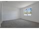 Bright bedroom features plush gray carpet, a large window, and white walls at 1655 Sugarbelle Cir, Mascotte, FL 34753
