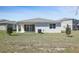 Rear exterior of a one-story home with a covered patio and expansive backyard at 1655 Sugarbelle Cir, Mascotte, FL 34753
