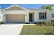 The front exterior features neutral tones, a two-car garage, a well-manicured lawn and an inviting front door at 1655 Sugarbelle Cir, Mascotte, FL 34753