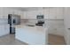 Modern kitchen with stainless steel appliances, white cabinets, a center island, and tile flooring at 1655 Sugarbelle Cir, Mascotte, FL 34753