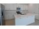 Bright kitchen with stainless steel appliances, a center island, white cabinets, and tile flooring at 1655 Sugarbelle Cir, Mascotte, FL 34753