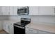 Close up of kitchen with stainless steel appliances, including a microwave and range stove at 1655 Sugarbelle Cir, Mascotte, FL 34753