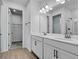 Bright bathroom featuring a double vanity, large mirror, and walk-in closet at 1667 Sugarbelle Cir, Mascotte, FL 34753