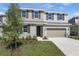 Charming two-story home with a manicured lawn, neutral color palette, and an attached two-car garage at 1667 Sugarbelle Cir, Mascotte, FL 34753