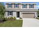 Inviting two-story home featuring a two-car garage, neutral siding, manicured lawn and a welcoming front entrance at 1667 Sugarbelle Cir, Mascotte, FL 34753