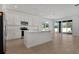 Bright kitchen features white cabinets, stainless steel appliances, island, and sliding glass doors to the backyard at 1667 Sugarbelle Cir, Mascotte, FL 34753