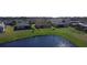 The rear exterior of the home, captured from a lake perspective, showing spacious landscaping and peaceful water scenery at 3960 Steer Beach Pl, Kissimmee, FL 34746