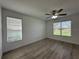 Bedroom with laminate flooring, ceiling fan and dual windows offering natural light at 3960 Steer Beach Pl, Kissimmee, FL 34746