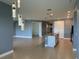 Open-concept living room with tile flooring and modern pendant lighting above the kitchen island at 3960 Steer Beach Pl, Kissimmee, FL 34746