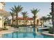 Luxurious swimming pool surrounded by palm trees and resort style buildings at 3960 Steer Beach Pl, Kissimmee, FL 34746
