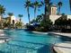 Expansive community pool with water slide, surrounded by lush tropical landscaping and elegant architectural details at 3960 Steer Beach Pl, Kissimmee, FL 34746