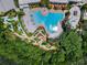 Aerial view of community resort pool, splash pad, and mini golf bordered by lush landscaping at 434 Captiva Dr, Davenport, FL 33896