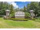Landscaped entrance to Harmony community featuring a stone sign, decorative towers, and vibrant green lawns at 7127 Harmony Square S Dr # 7127, Harmony, FL 34773