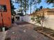 View of side yard with brick-paved area, storage shed, and white vinyl fencing at 438 Spike Ct, Kissimmee, FL 34759