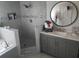 Elegant bathroom with walk-in shower, soaking tub, gray vanity, and stylish gray tile at 438 Spike Ct, Kissimmee, FL 34759