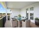 Covered balcony with an outdoor table and seating for six, overlooking beautiful landscaping at 13193 Tollcross Way, Winter Garden, FL 34787