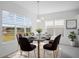 Dining room with modern decor, natural lighting, and views of a pond at 13193 Tollcross Way, Winter Garden, FL 34787