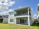 Rear view of a two-story home with a covered patio and balcony overlooking a well-manicured lawn at 13193 Tollcross Way, Winter Garden, FL 34787