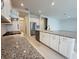 Stylish kitchen with a gas range, stainless steel appliances, granite counters, and white cabinets at 13193 Tollcross Way, Winter Garden, FL 34787